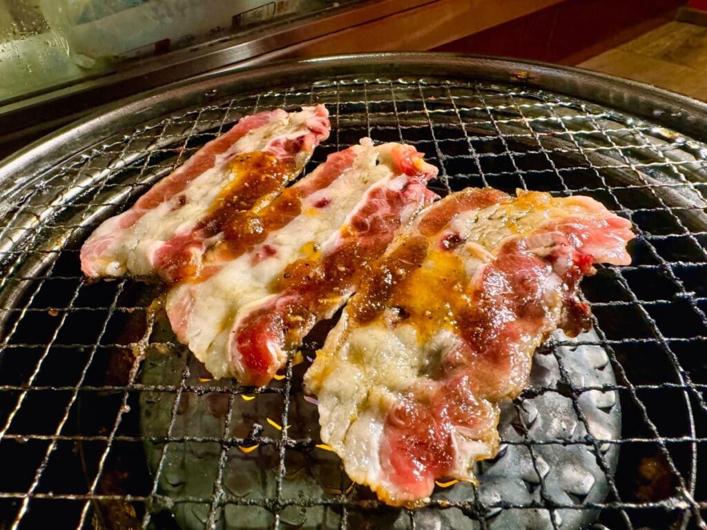 焼肉食べ放題やる気 四条河原町店の焼きすきカルビ 卵つき 調理中